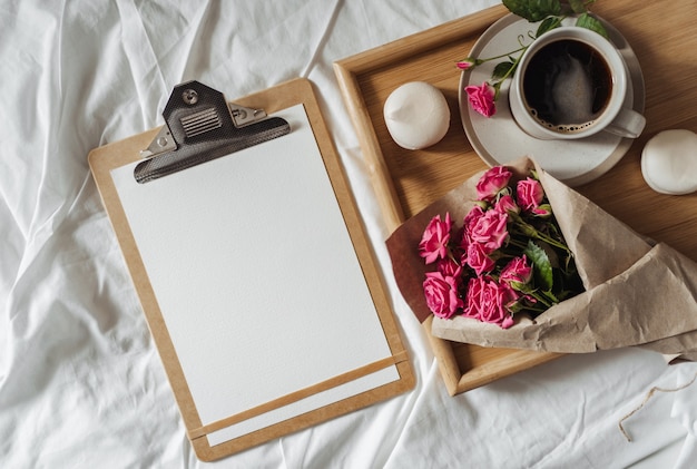 Bouquet di fiori primaverili e una tazza di caffè su un vassoio di legno a letto