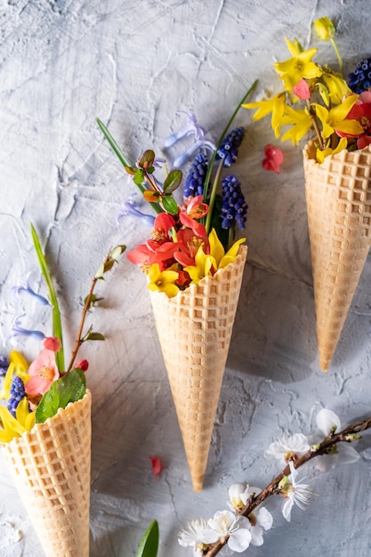 bouquet di fiori primaverili luminosi in una tazza di waffle sfondo vista piatta spazio per il testo