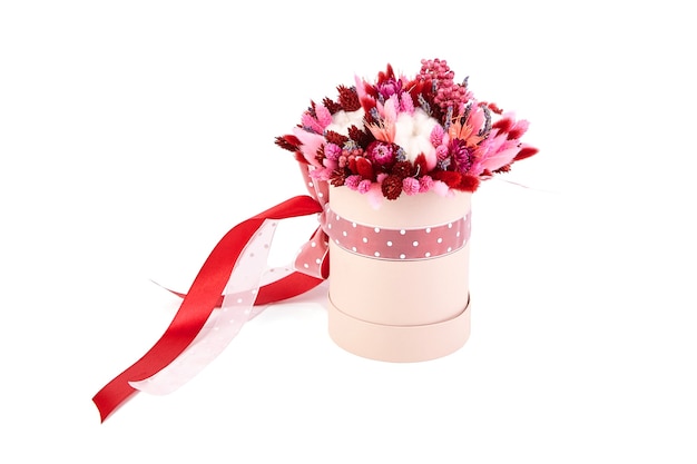 Bouquet di fiori secchi con erbe in scatola di cappelli tonda rosa isolata su sfondo bianco