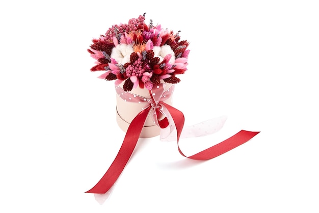 Bouquet di fiori secchi con erbe in scatola di cappelli tonda rosa isolata su sfondo bianco