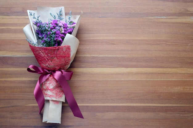 Bouquet di fiori su sfondo di legno banner con spazio di copia vista dall'alto piatto