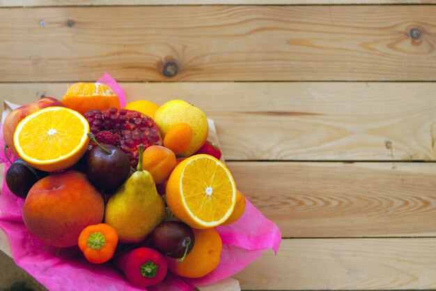 Bouquet di frutta fresca sul tavolo di legno piatto, giorno del ringraziamento, cibo ecologico sano, messa a fuoco selettiva