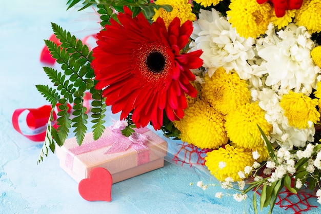 bouquet di gerbera con crisantemi con cuori e presente.