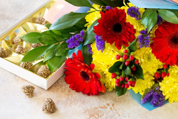 bouquet di gerbera con crisantemi e dolci.