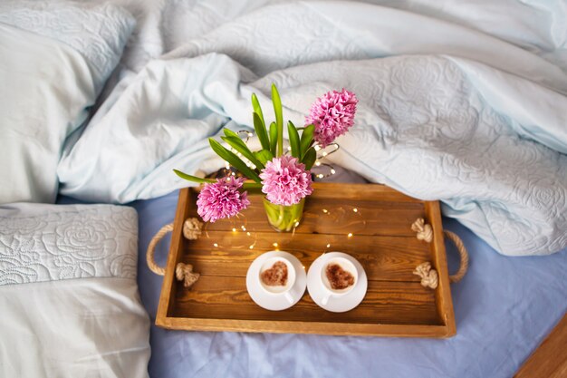 Bouquet di giacinti, due tazze di cappuccino. Colazione a letto.