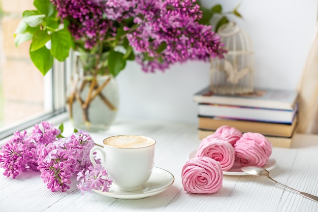 Bouquet di lillà, tazza di caffè, marshmallow fatti in casa. Romantica mattina di primavera