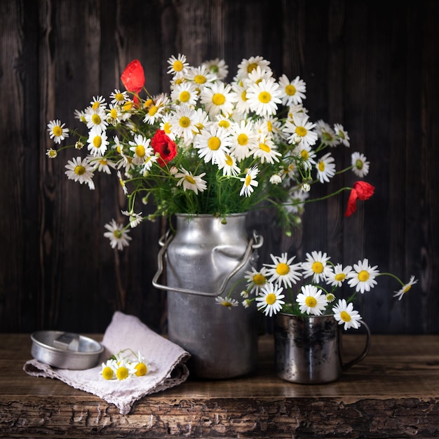 Bouquet di margherite e papaveri su un tavolo rustico