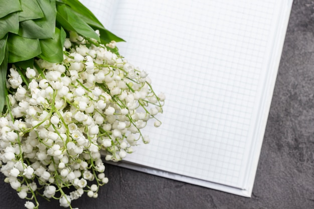 Bouquet di mughetti sulla pagina del taccuino aperto.