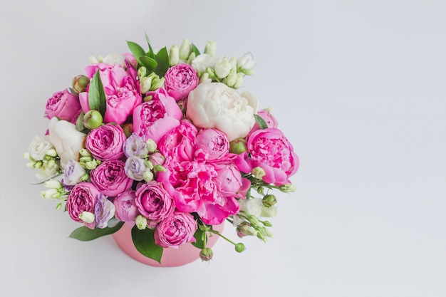 Bouquet di peonie, eustoma, spray rose in una scatola rosa con un&#39;oasi