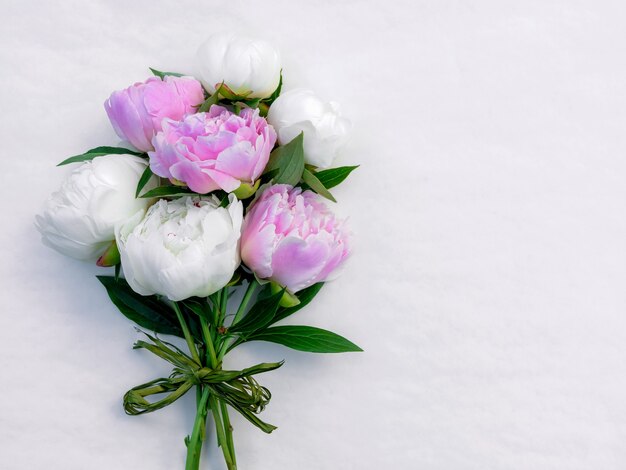 Bouquet di peonie rosa e bianche ravvicinate con copia spazio per il design.