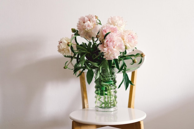 Bouquet di peonie rosa su una sedia bianca nel soggiorno Festa della mamma Amore e concetto romantico