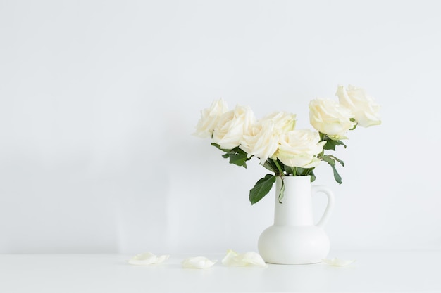 Bouquet di rose bianche in brocca su sfondo bianco