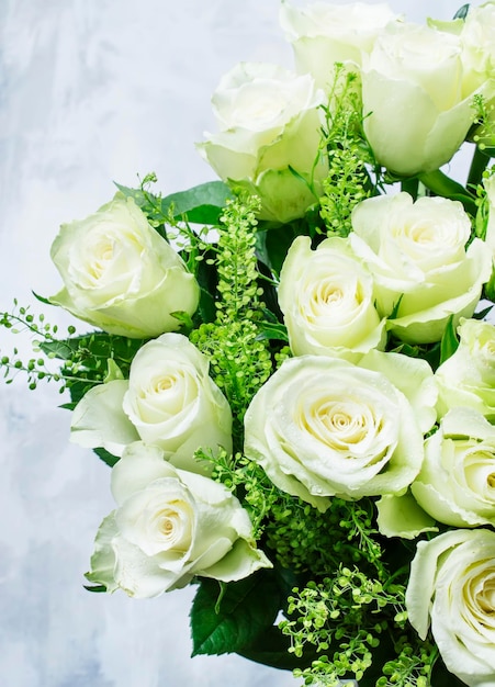 Bouquet di rose bianche per il fuoco selettivo del fondo grigio della festa della donna