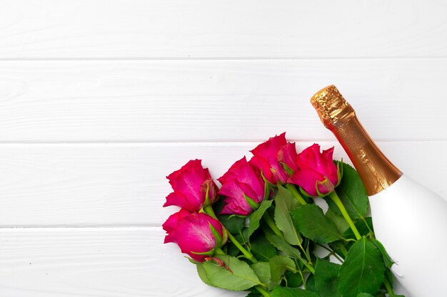 Bouquet di rose e champagne vista dall'alto piatto laici