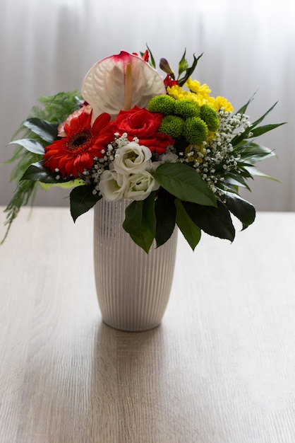 bouquet di rose e crisantemi in un vaso sul tavolo