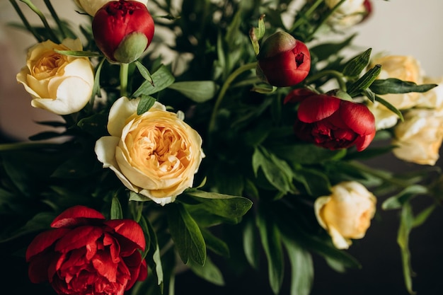 Bouquet di rose gialle e peonie rosse sparate da vicino