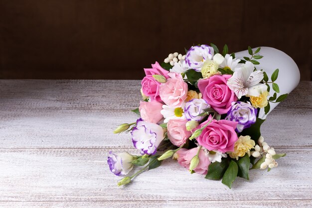 Bouquet di rose, margherite, lisianthus, crisantemi, boccioli non aperti in una scatola rotonda bianca