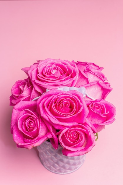 Bouquet di rose rosa fresche in un secchio. Il concetto festivo per matrimoni, compleanni, 8 marzo, festa della mamma o San Valentino. Biglietto di auguri, sfondo rosa chiaro