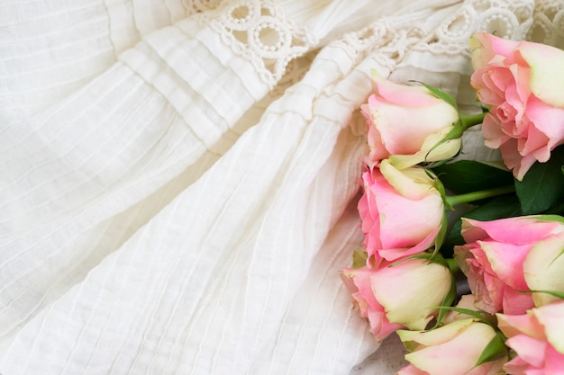 Bouquet di rose rosa su sfondo abito da sposa