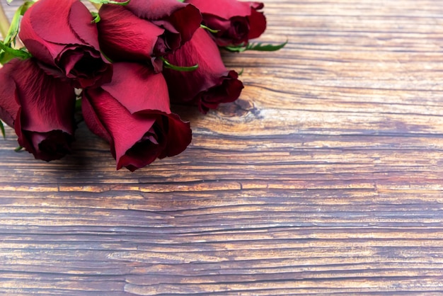 Bouquet di rose rosse con spazio di copia su sfondo di legno