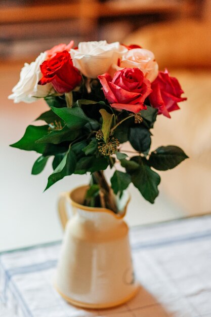 Bouquet di rose rosse e bianche in un vaso sul tavolo