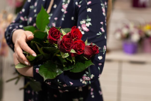 Bouquet di rose rosse Idea regalo per San Valentino Fiorista donna con in mano un bouquet fresco