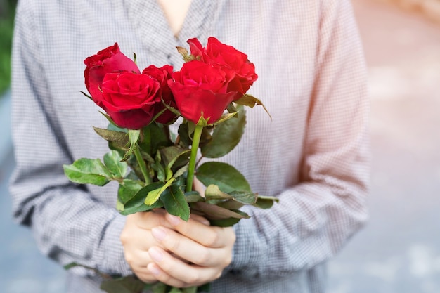 Bouquet di rose rosse nelle mani di Womans