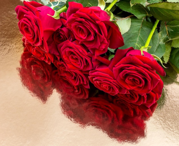 Bouquet di rose rosse su fondo dorato riflettente