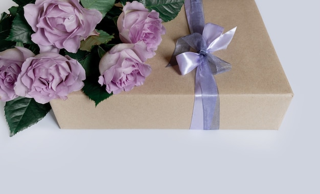 Bouquet di rose viola con confezione regalo su sfondo bianco, vista dall'alto, spazio copia.