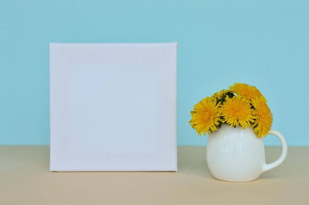 Bouquet di tarassaco in vaso e cornice su sfondo blu