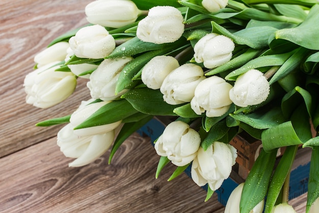 Bouquet di tulipani bianchi freschi sulla tavola di legno