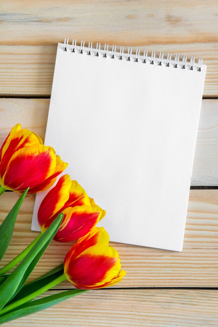 Bouquet di tulipani freschi e scheda vuota vuota per lo spazio della copia sopra il fondo della tavola in legno.