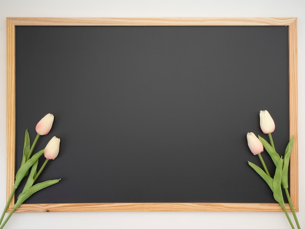 Bouquet di tulipani posto sulla cornice della lavagna