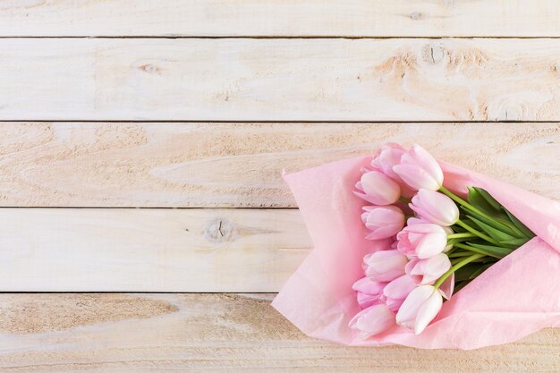 Bouquet di tulipani rosa avvolto in carta rosa.