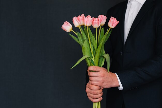 Bouquet di tulipani rosa nelle mani di un uomo