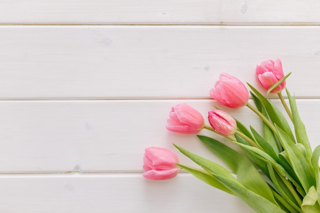 Bouquet di tulipani rosa su sfondo di legno bianco Spazio per la copia vista dall'alto