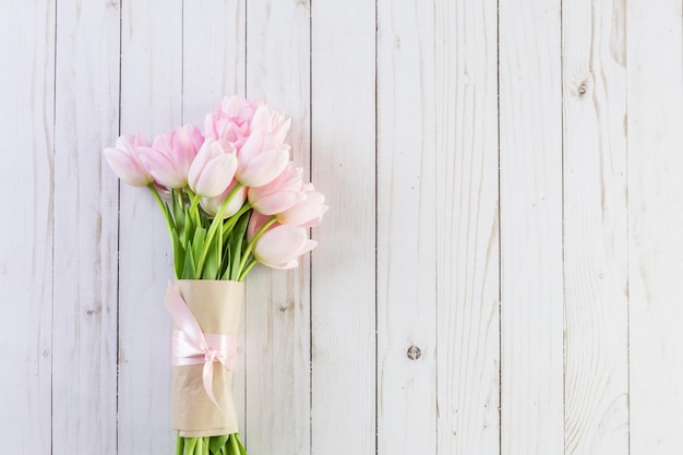 Bouquet di tulipani rosa su uno sfondo di legno.