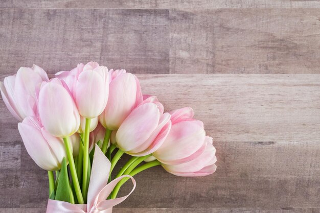 Bouquet di tulipani rosa su uno sfondo di legno.