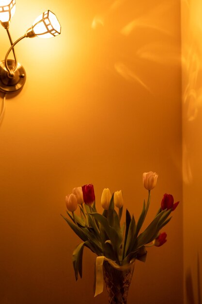 Bouquet di tulipani sul comodino alla luce delle applique in camera da letto