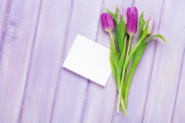 Bouquet di tulipani viola e biglietto di auguri vuoto