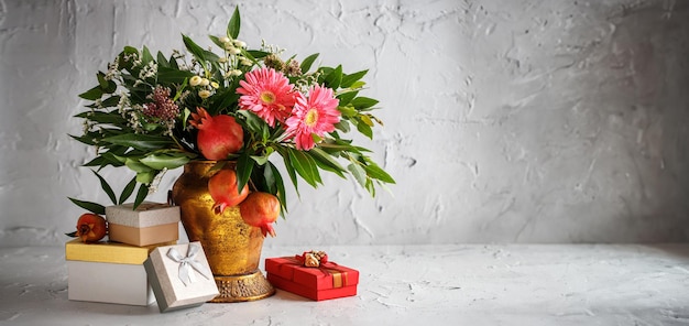 Bouquet festivo di scatole regalo di fiori e frutti di melograno concetto di capodanno ebraico rosh hashanah