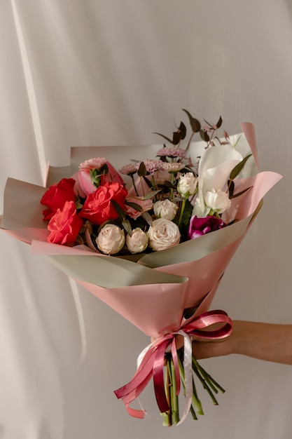 Bouquet luminoso con rose rosse callala crisantemo rose pionoidi in confezione rosa