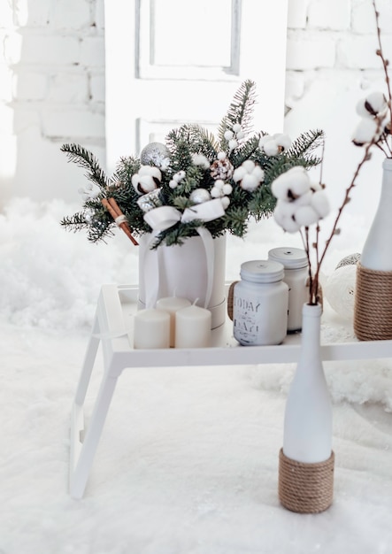 Bouquet natalizio di abete e cotone in un interno bianco. Buon anno.