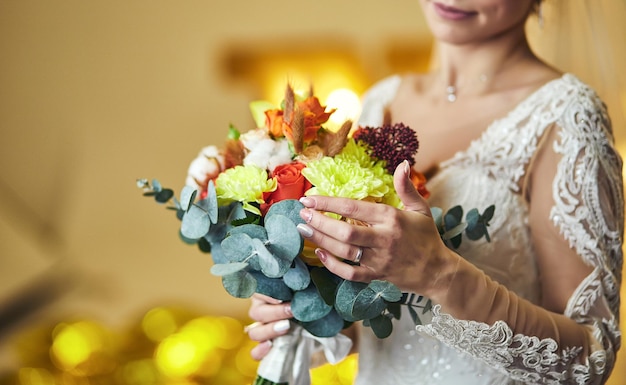 Bouquet nelle mani della donna sposa che si prepara prima della cerimonia di nozze