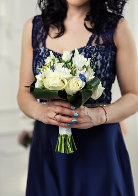 Bouquet nelle mani della donna sposa che si prepara prima della cerimonia di nozze