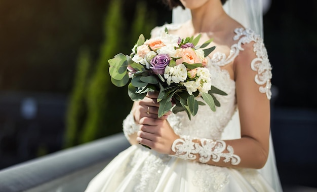 Bouquet nelle mani della donna sposa che si prepara prima della cerimonia di nozze