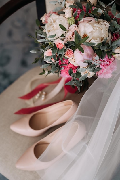 Bouquet scarpe e gioielli della sposa sulla sedia 3789