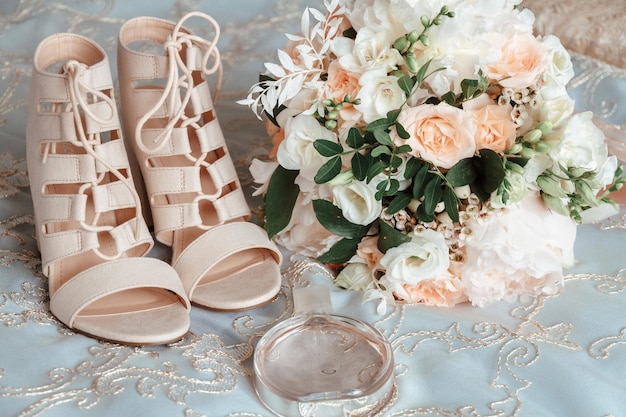 Bouquet sposa scarpe beige fedi nuziali e profumo Gli accessori della sposa Mattina di nozze