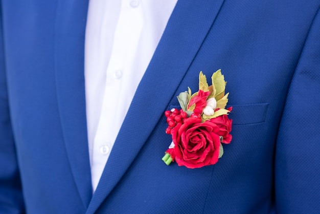 Boutonniere rosso su una giacca blu.