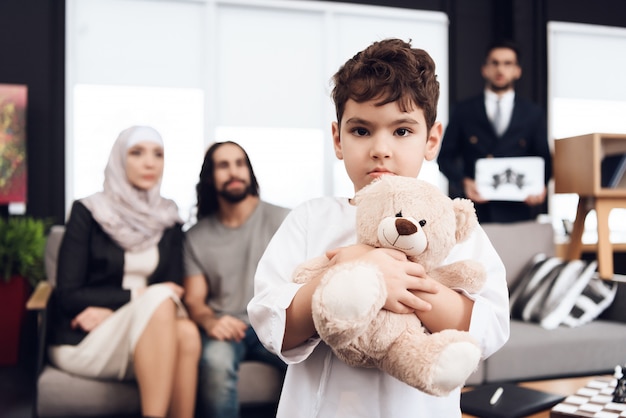 Boy is Holds Teddy Bear. I genitori stanno guardando il figlio.